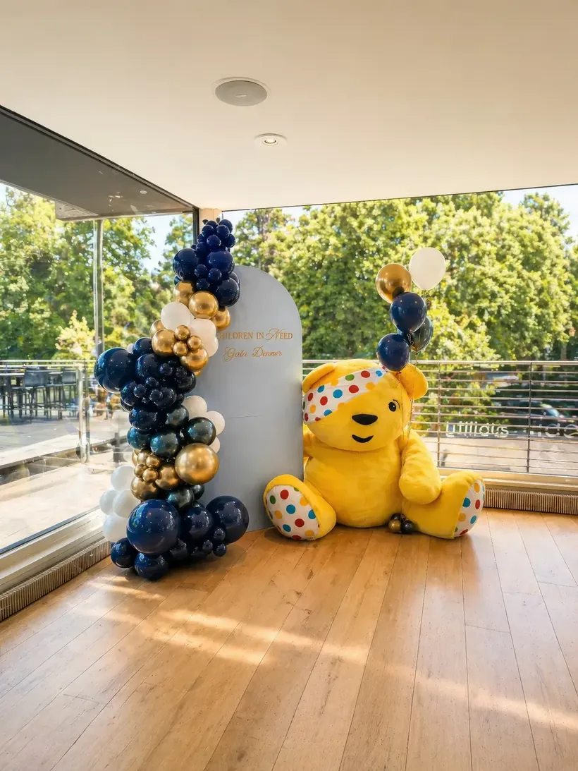 Corporate gala styling in Surrey by River Fox Events - navy, gold and cream balloons with branded Children in Need backdrop