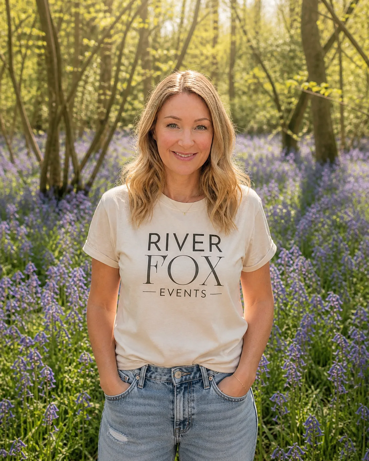 Laura, founder of River Fox Events, photographed amongst Surrey bluebells in a River Fox Events tee - event stylist for children's parties, milestones and brand celebrations