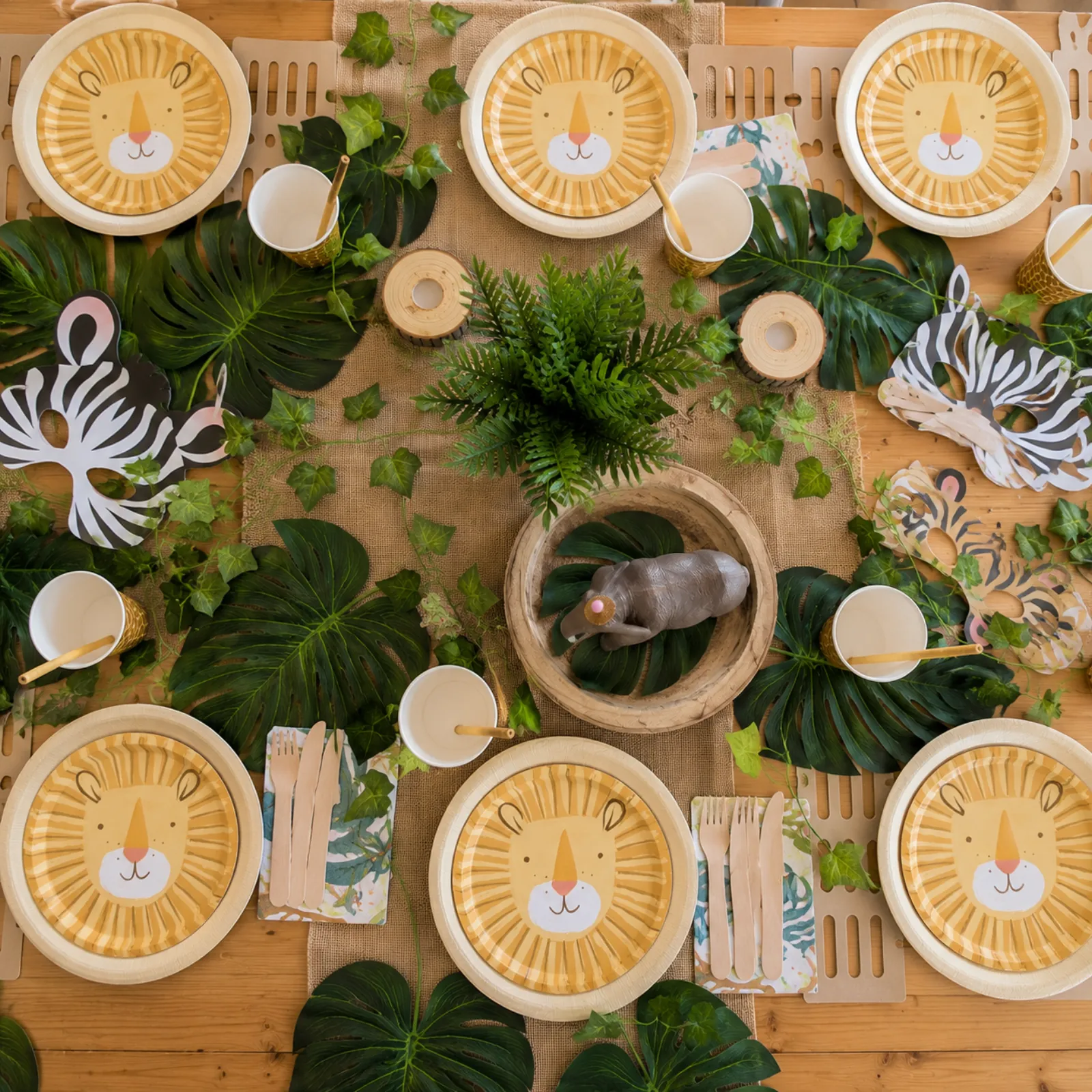 Jungle theme overhead place setting by River Fox Events - lion-printed plates with raffia and animal-print napkins